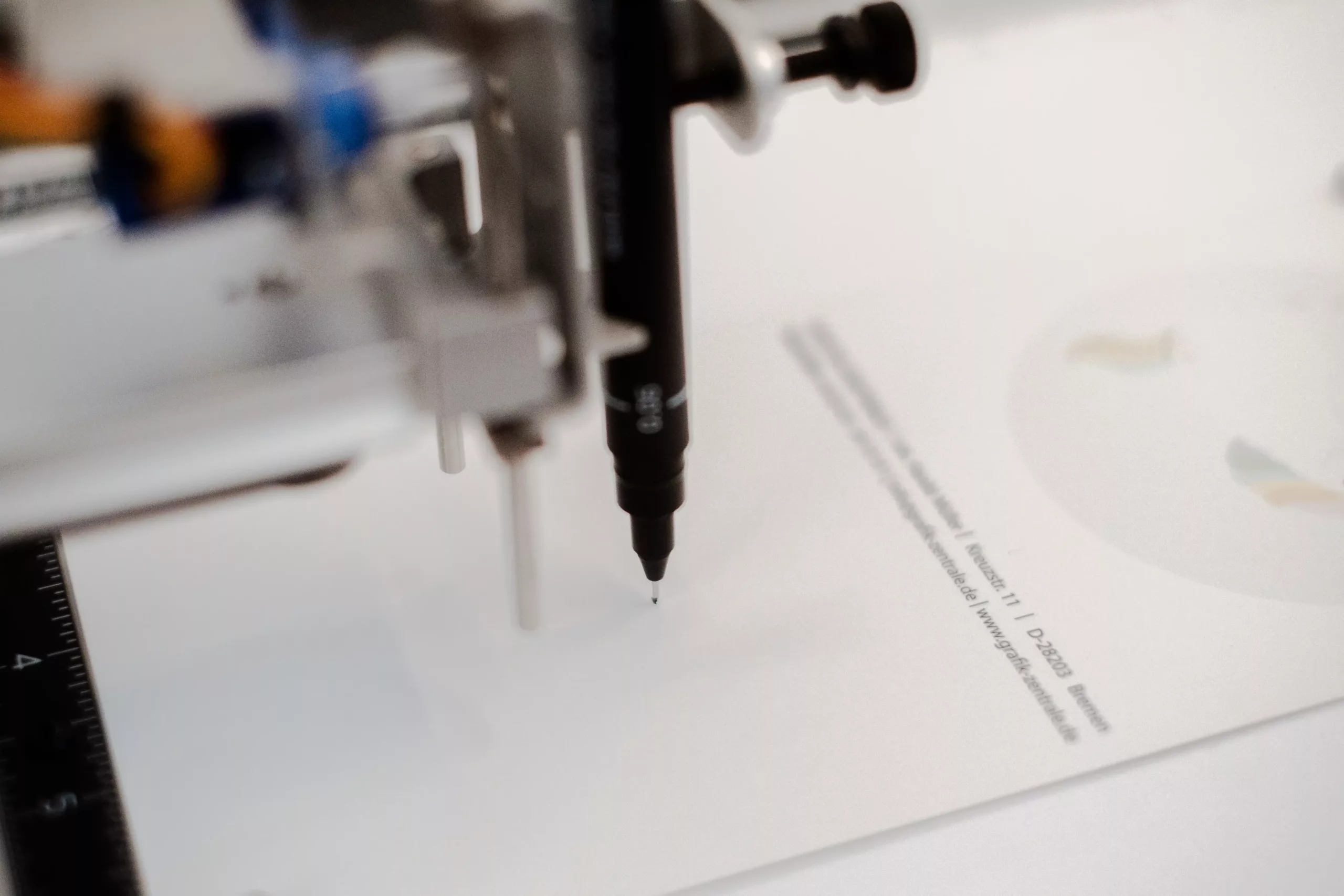 Ein mit einem Stift ausgestatteter Roboterarm schreibt einen Text auf ein Blatt Papier und demonstriert damit die automatische Handschrifttechnologie.