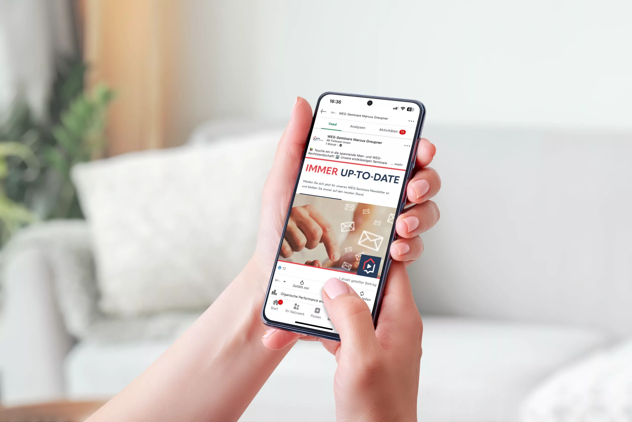 Eine Person hält ein Smartphone in der Hand und surft auf einer Website mit der Überschrift "IMMER UP-TO-DATE" und Symbolen für E-Mail und Kommunikation, während sie auf einer hellen Couch sitzt.